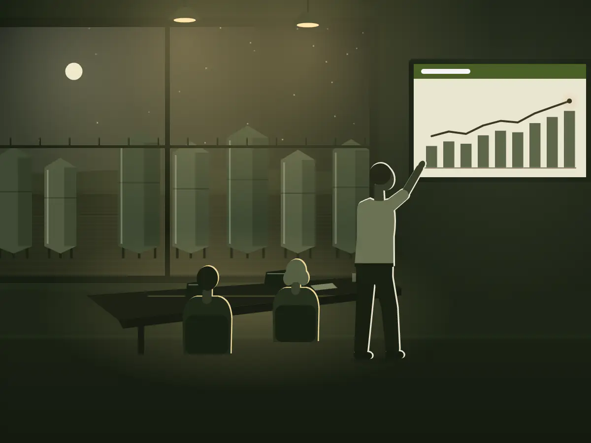 A general manager points to the year's growth on the screen in a late meeting above a lit winery tank farm.
