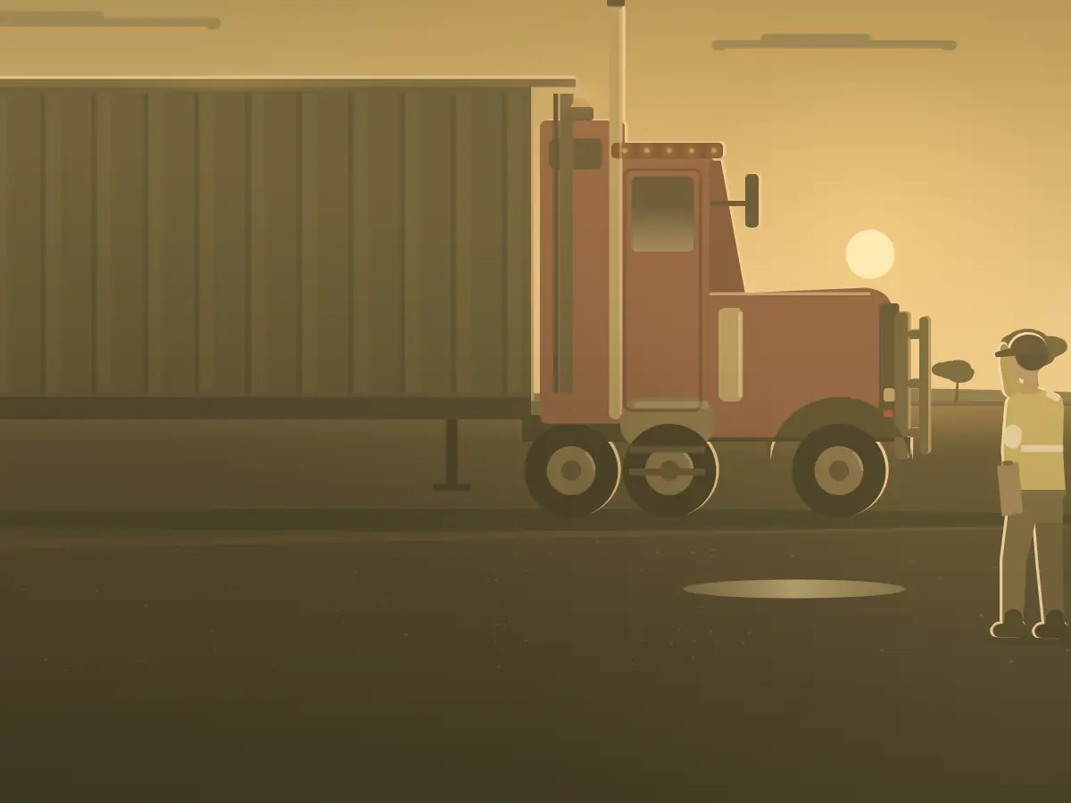 A truck driver in hi-vis checks a road train at a country truck stop.