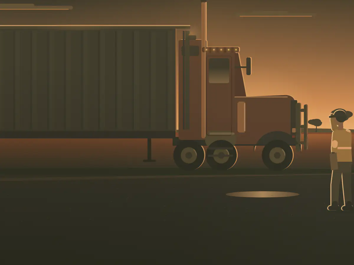 A truck driver in hi-vis checks a road train at a country truck stop.