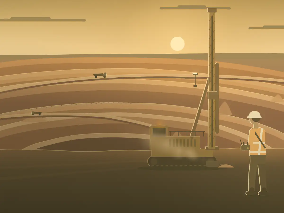 A driller in hi-vis works a blast-hole rig by remote on a bench of a red-earth open cut.