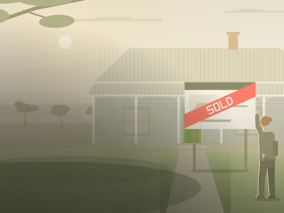 A real estate agent presses a SOLD strip across the sign in front of a country cottage.