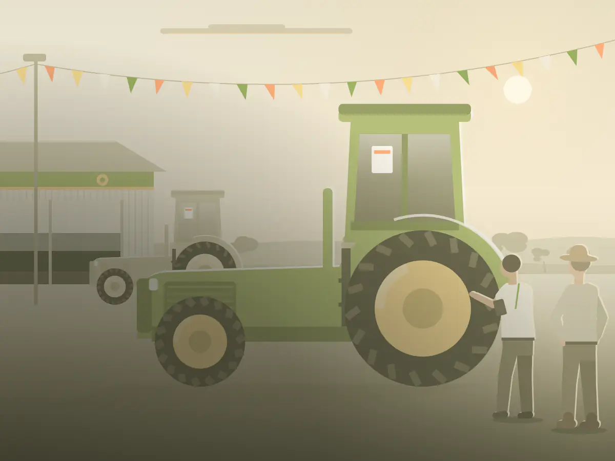 A sales rep at a country machinery dealership shows a farmer around a new tractor.