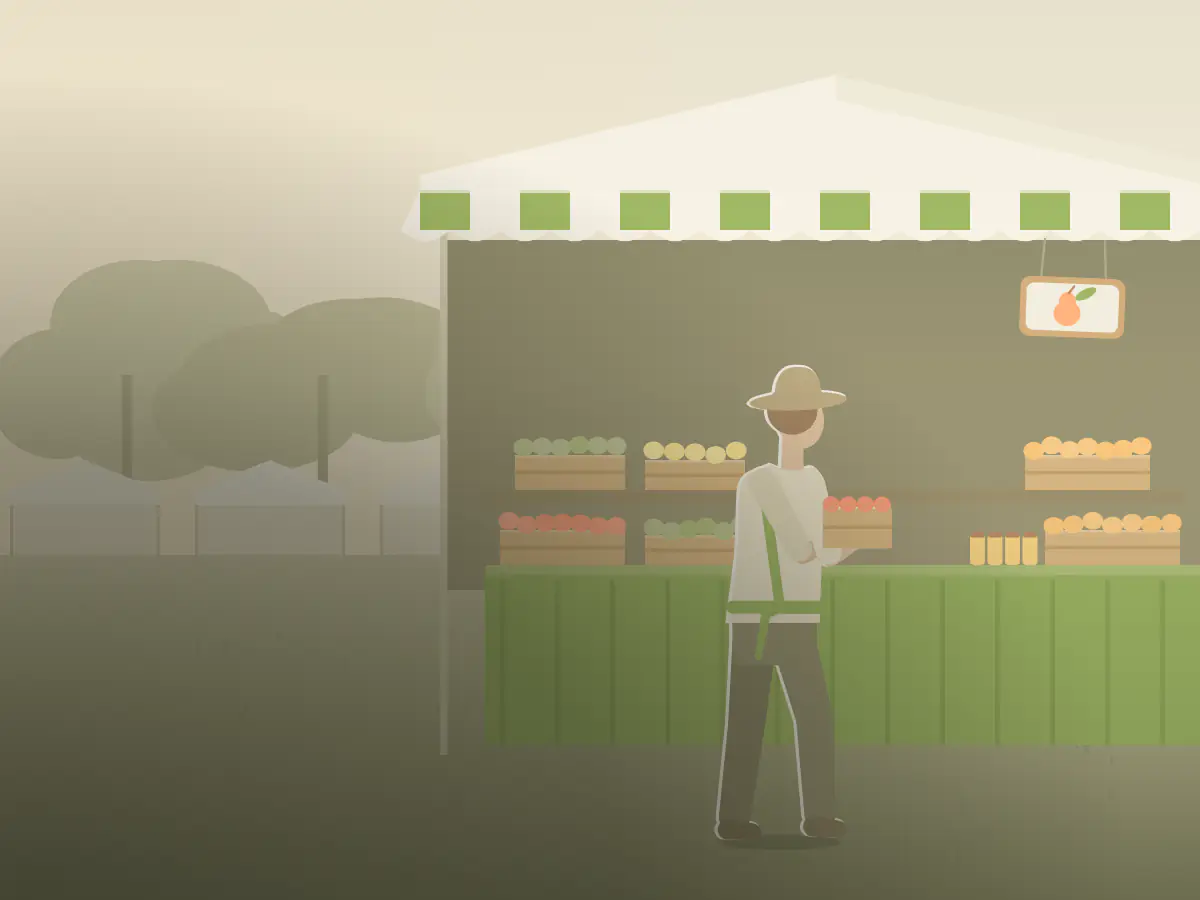 A grower sets out a crate of produce at a farmers' market stall.
