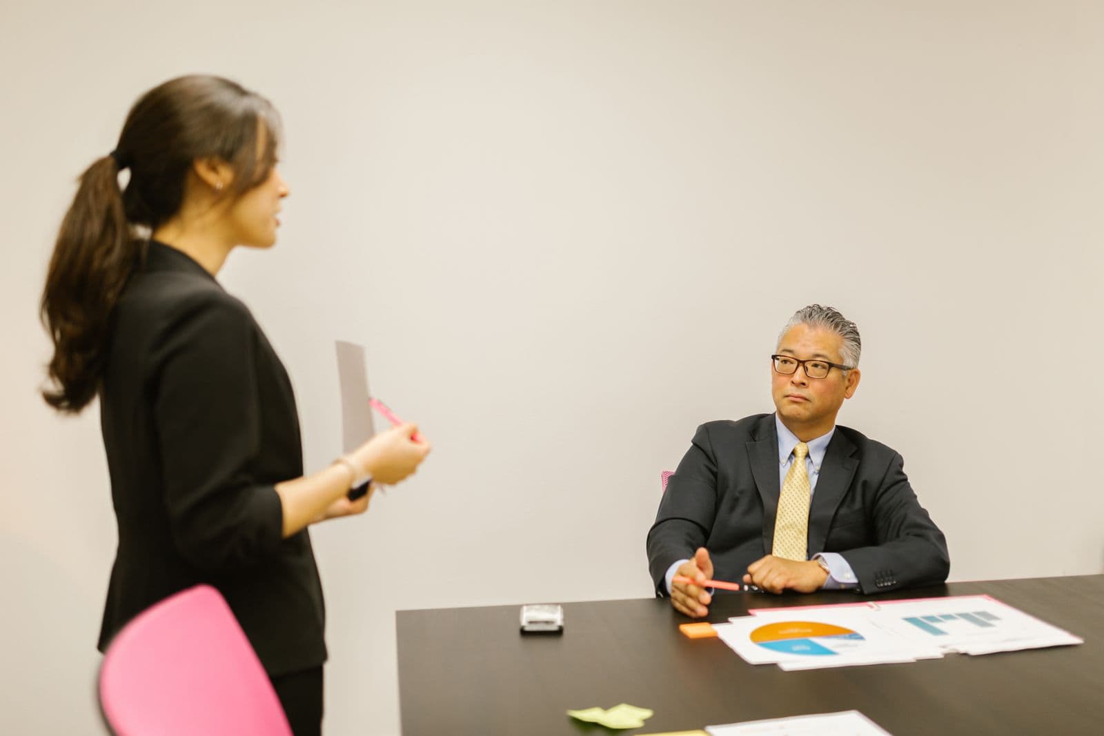 A professional making her case to a manager across a meeting table