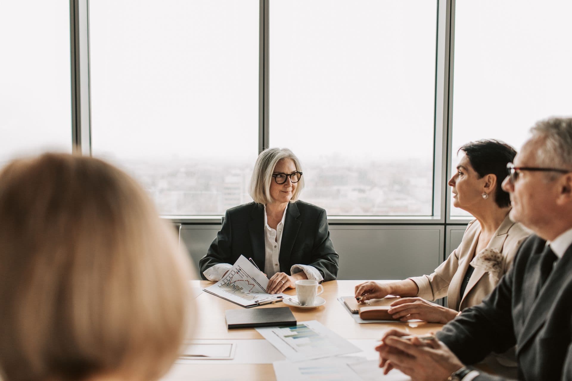 Senior executives in conversation beside a window in a modern office